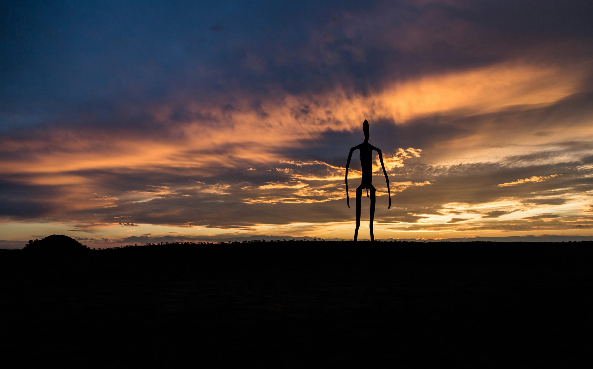 Silhouette of a cculpture by Antony Gormley in Lake Ballard, Australia